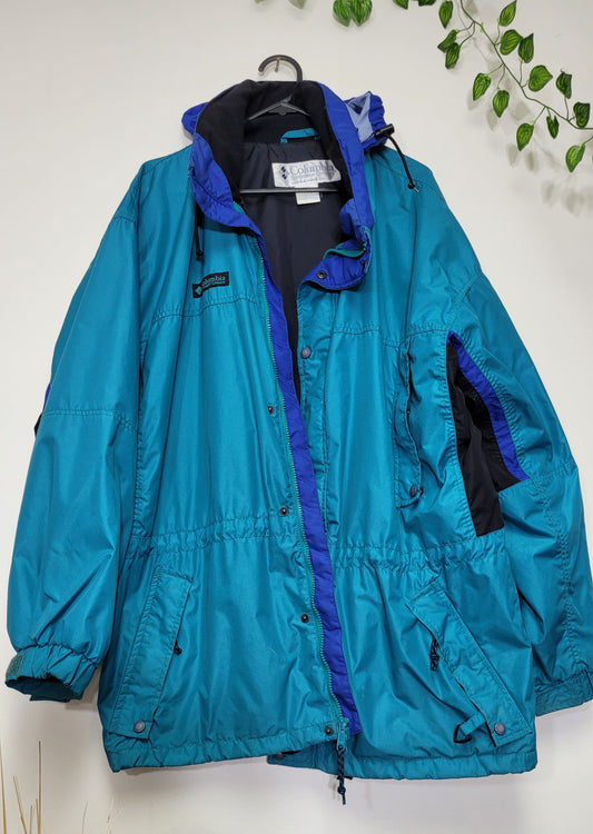 A vintage Columbia ski sportswear longs peak jacket in blue with zippered pockets and a visible brand logo on the chest.