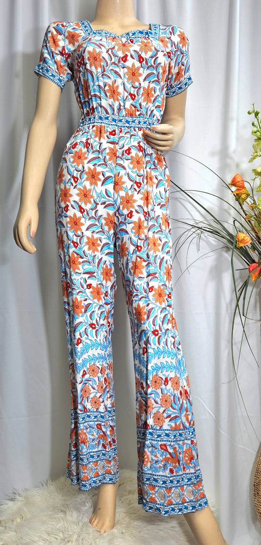 A bohemian wide-leg jumpsuit with a floral pattern in shades of blue and orange. The jumpsuit has short sleeves and a round neckline, in preloved condition. available in Auckland