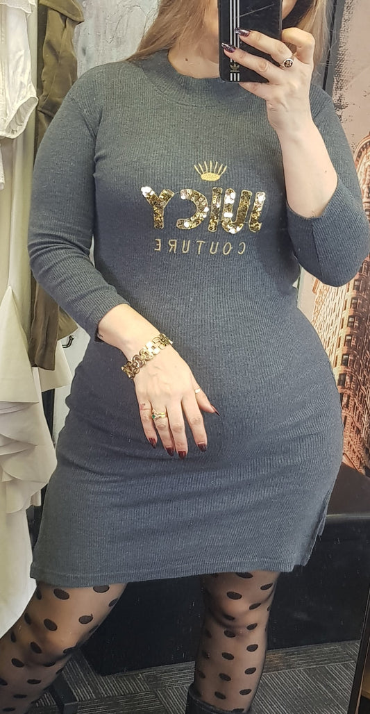 A person wearing a gray dress with 3/4 sleeves, featuring a text 'Juicy' on the front, reflecting light-colored knit fabric.