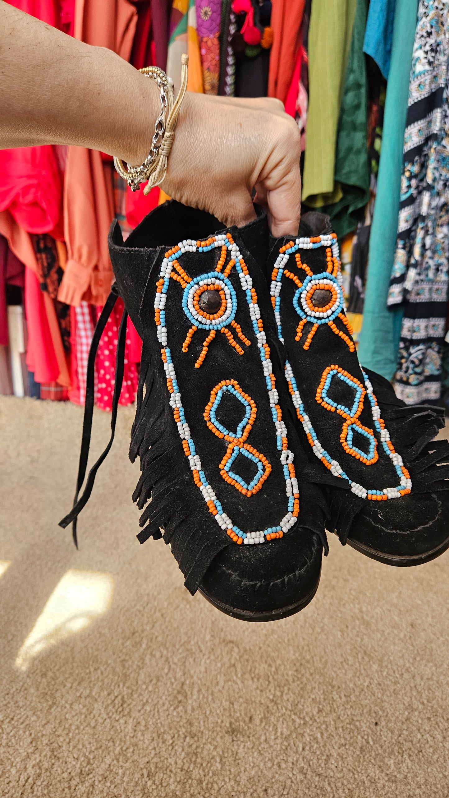 Artisanal boots with beads held by a hand against in good preloved condition, size 9
