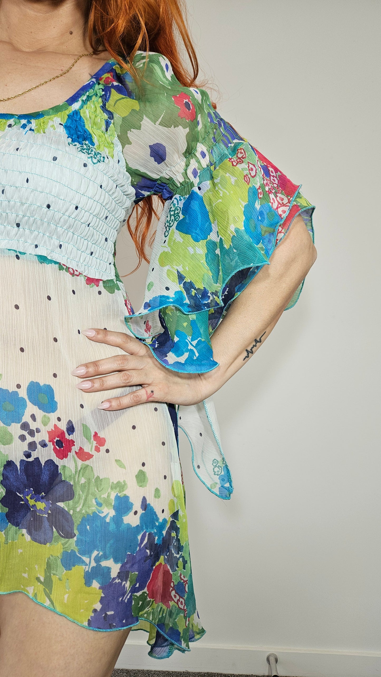 Close-up of sheer floral flutter sleeve with layered ruffle detailing and turquoise edging on Italian boho dress.