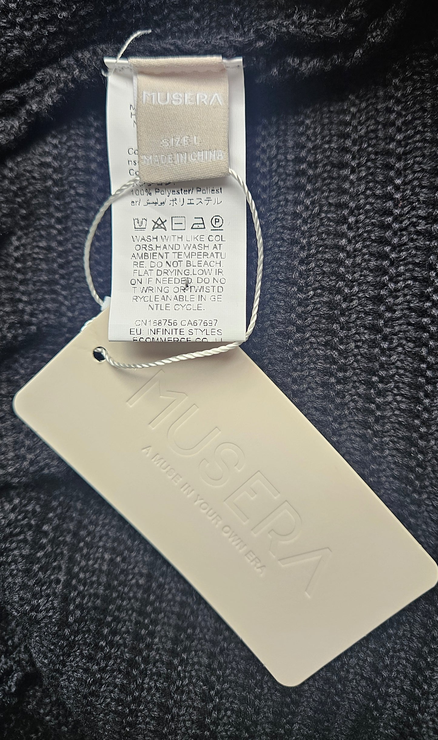musera tags on a textured fabric background. knit dress Size L